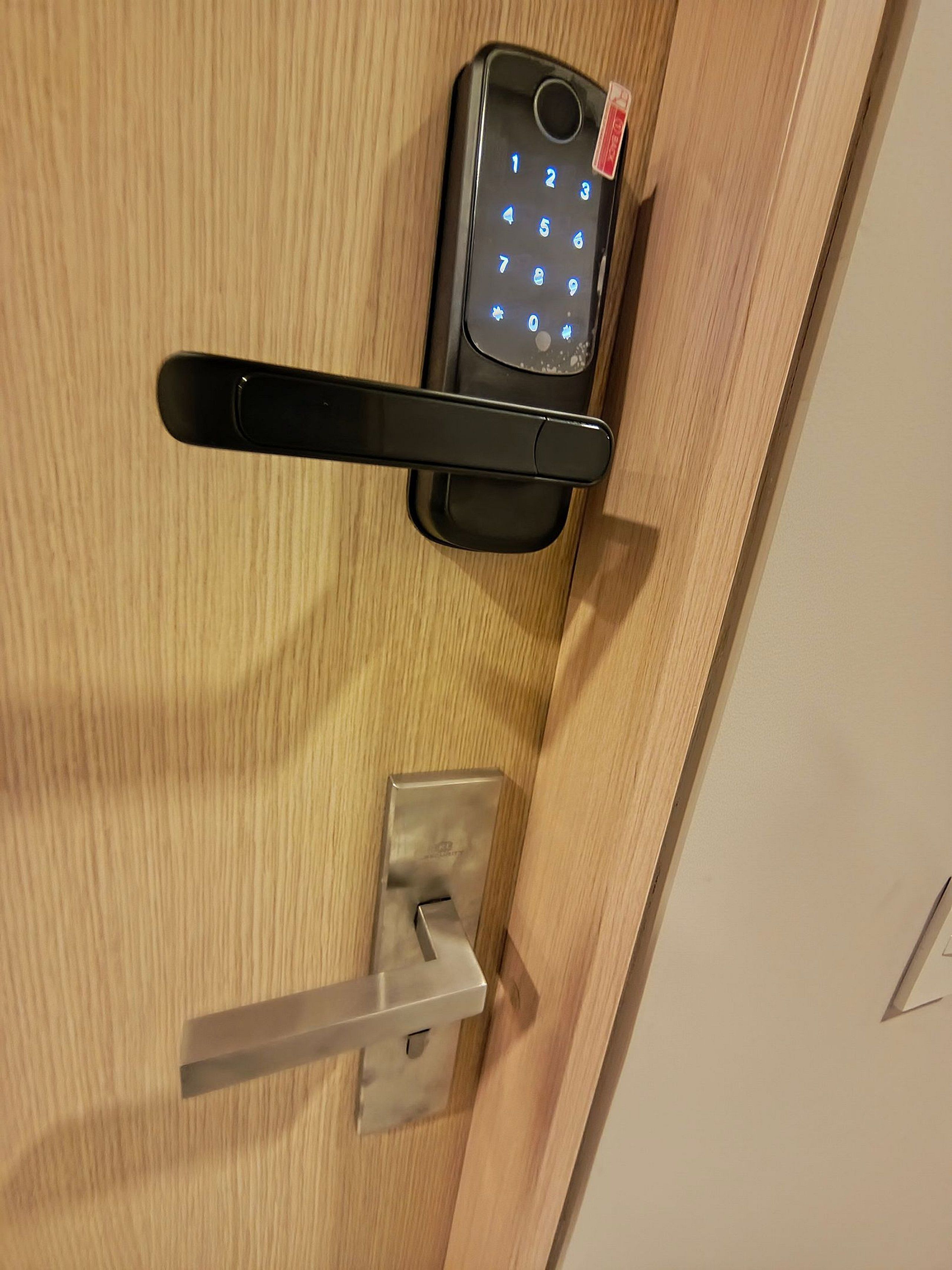 A door with a numeric keypad lock and a lever handle.
