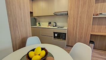 Una cocina moderna con armarios de madera, microondas integrado y cafetera.