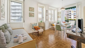 Una habitación amplia con cama, zona de comedor y televisión.