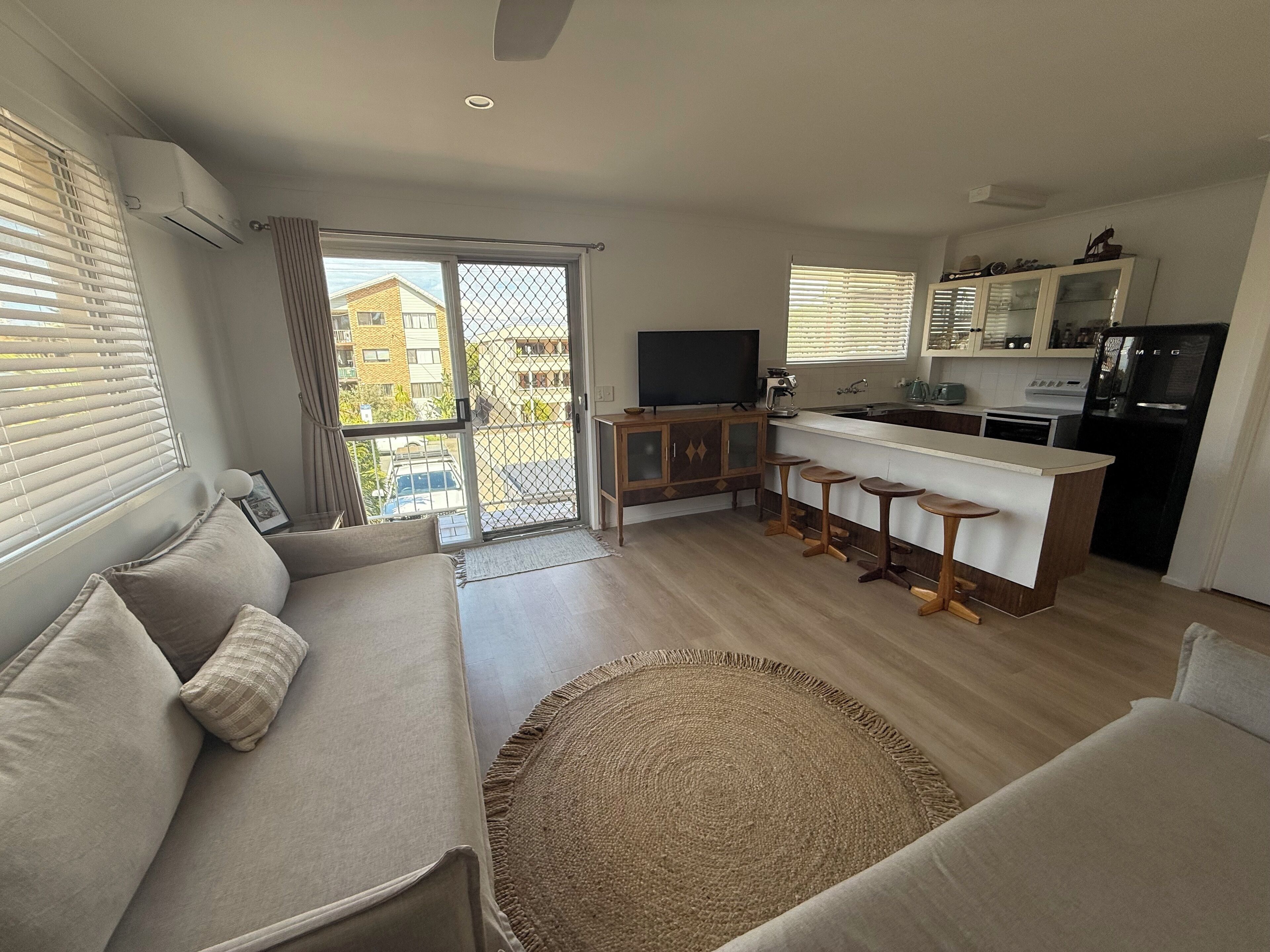 Eine moderne Wohnung mit Wohnzimmer, Küche und Balkon.
