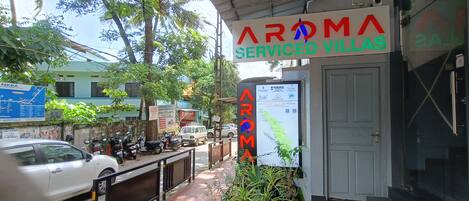 A building with a sign reading "Aroma Serviced Villas".