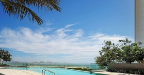 A swimming pool with a clear view of the city skyline in the background.
