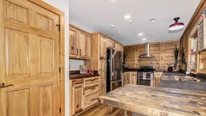A kitchen with wooden cabinets, a stainless steel refrigerator, and a wooden countertop. - Gateway Getaway with Mountain Views and Fireplace (Old Fort)