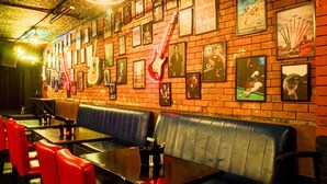 A restaurant with brick walls, framed pictures, and red and black seating. - Townhouse Oak Viman Nagar Hotel Cilantro (Pune)