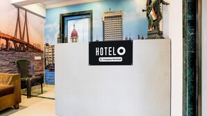 A hotel reception area with a sign reading "HOTEL O" and "Company-Serviced".