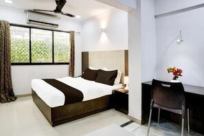 A modern hotel room with a large bed, a desk, and a chair. - Super Hotel O Four Bungalow (Mumbai)