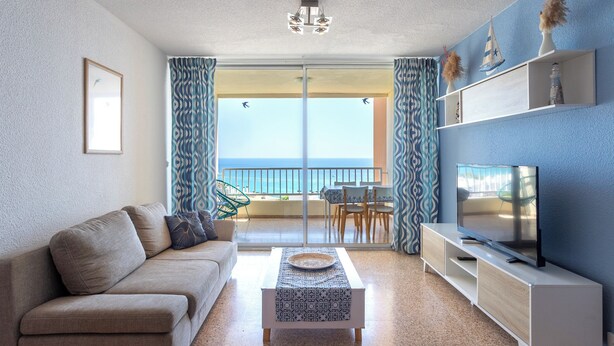 A modern living room with a sofa, coffee table, TV, and a balcony with a view. - Paradise View (Villajoyosa)