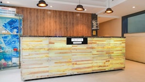 A reception desk with a 'PALETTE' sign, wooden paneling, and pendant lighting. - Palette Sapphire Star (Indore)