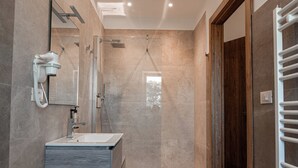 A modern bathroom with a glass-enclosed shower, a vanity with a marble countertop, and a wooden door. - Manfredomus Farmhouse (Mussomeli)