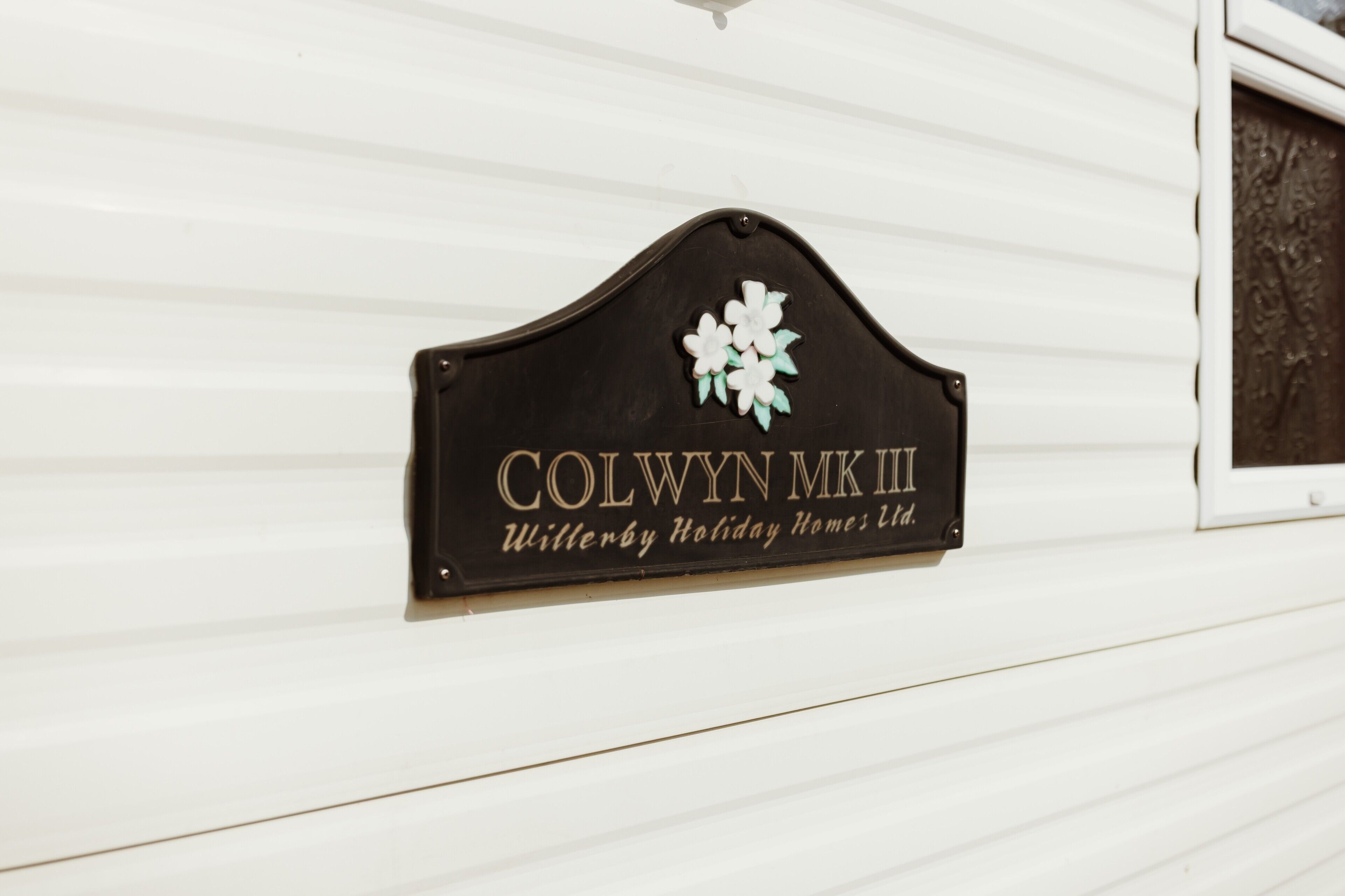 A sign with the text 'COLWYN MK III' and 'Witwyby Holiday Homes Ltd.'