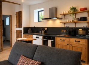 A modern kitchen with wooden cabinets, a built-in oven, and a microwave.
