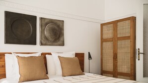 A neatly made bed with striped bedding, two pillows, and a bedside lamp. - Evas Apartment in the Heart of Chania City (Chania)