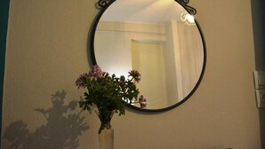 Un espejo redondo con un marco decorativo en la pared.