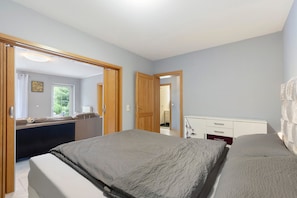 Une chambre à coucher avec un lit, une commode et une fenêtre.
