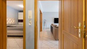 A room with a bed, a desk, a chair, a lamp, and a television. - Apartment 'Am Wasser 2' with Lake View, Shared Terrace, and Wi-Fi (Groß Lindow)