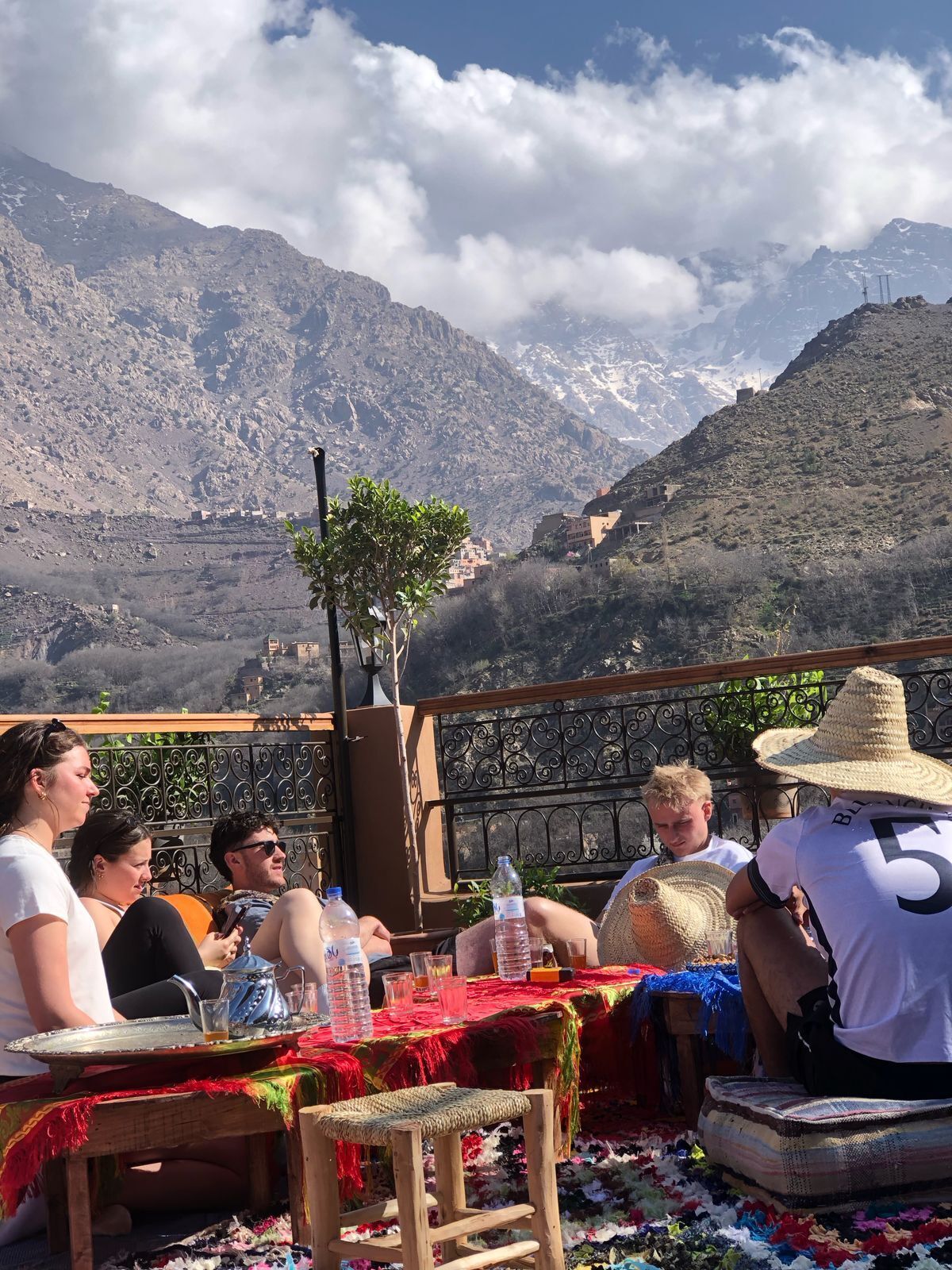 Un grupo de personas sentadas en una mesa con vistas a montañas al fondo.