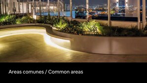A nighttime view of a rooftop terrace with a curved pool, plants, and a cityscape in the background. - Luxury Loft in San Jose CR (San José)