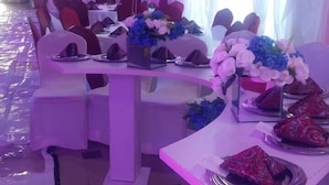 A banquet hall with tables set for a formal event, featuring floral centerpieces and white tablecloths. - Stanzel Grand Resort (Abuja)