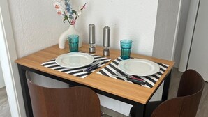 A dining table with two chairs, a vase with flowers, and salt and pepper shakers. - Charming house in Bale -Leymen - Your perfect home for your pets (Leymen)