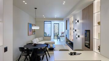 A modern kitchen with a dining area, large windows, and a view of the city.