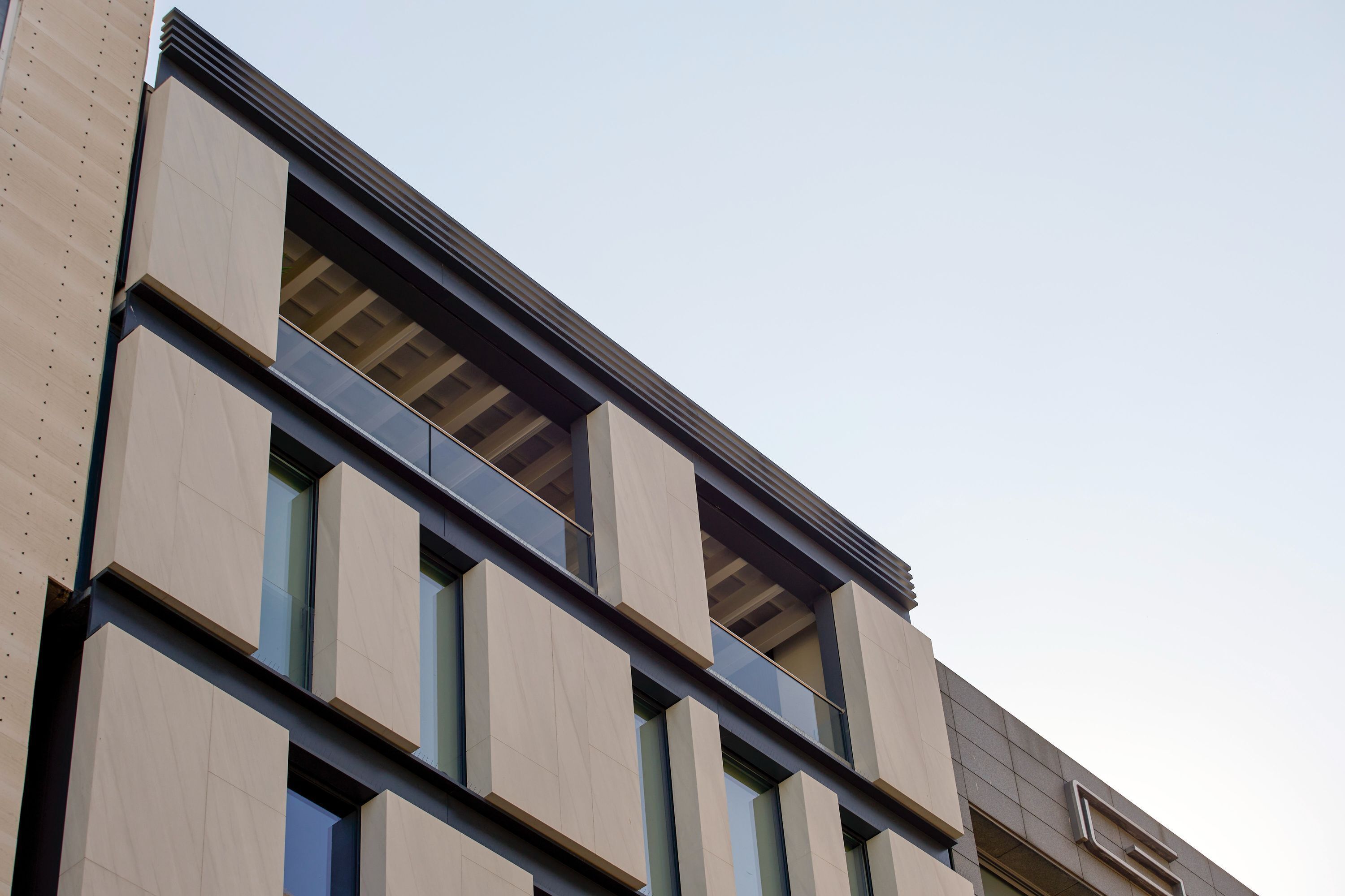 A modern building facade with large windows and a flat roof.