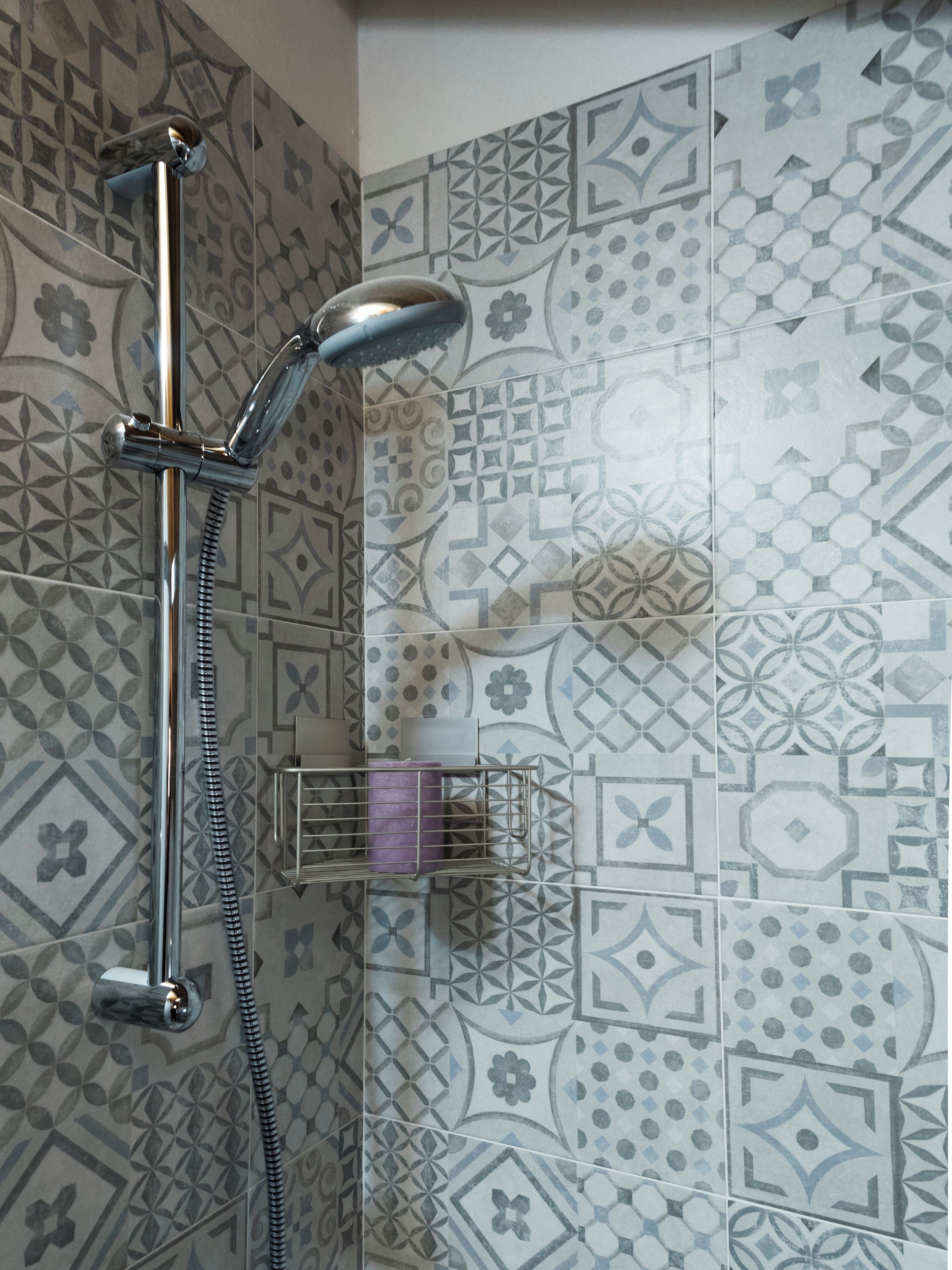 Eine Dusche mit Handbrause und einer fest installierten Armatur.