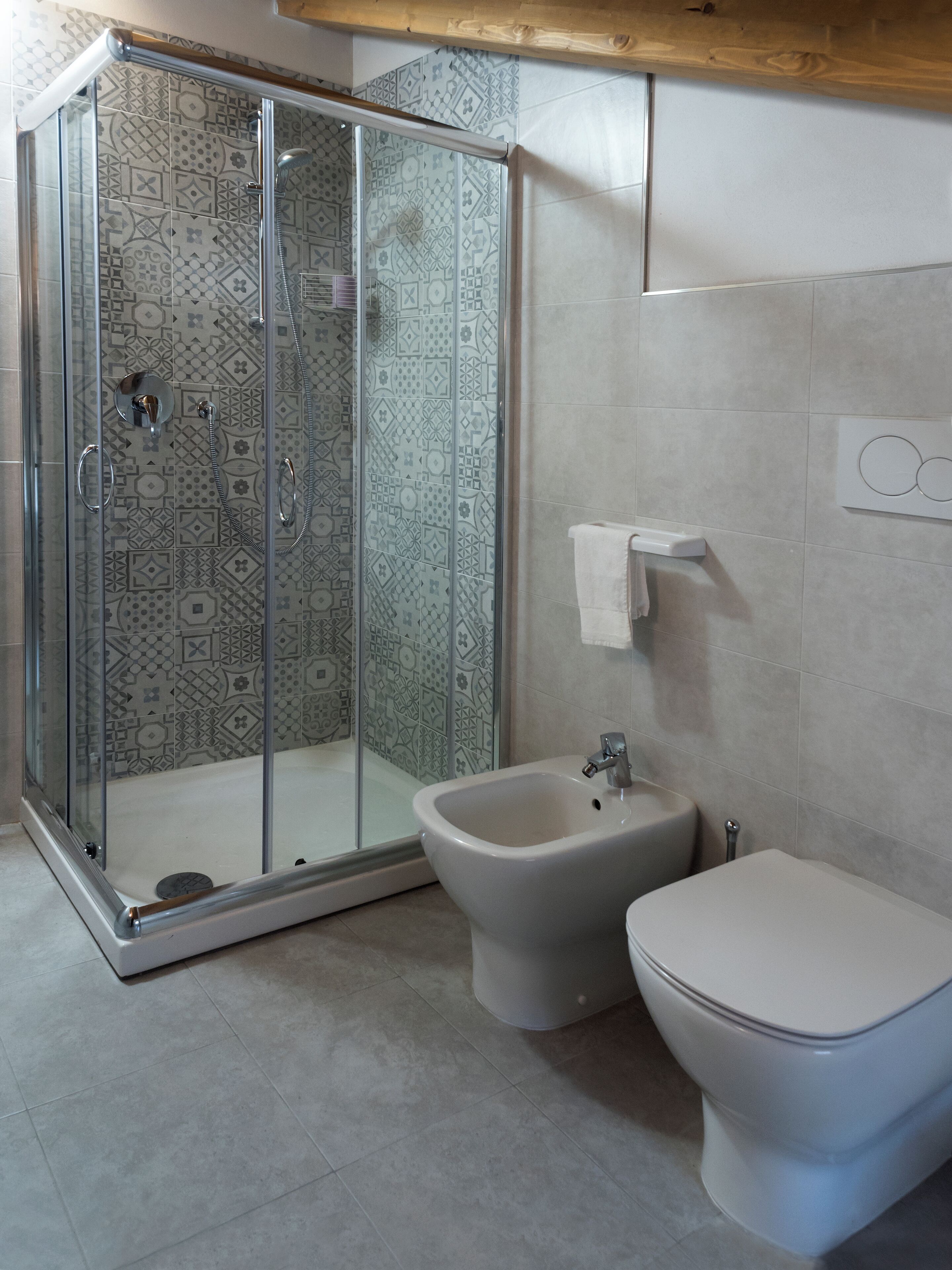 Un baño con cabina de ducha, bidé e inodoro.
