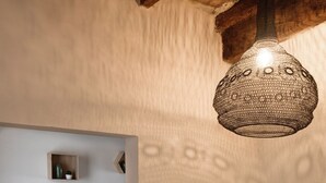 A dining area with a table and chairs, a hanging light fixture, and a wooden ceiling. - Borgodieci Camere e Colazione (Bibbiano)