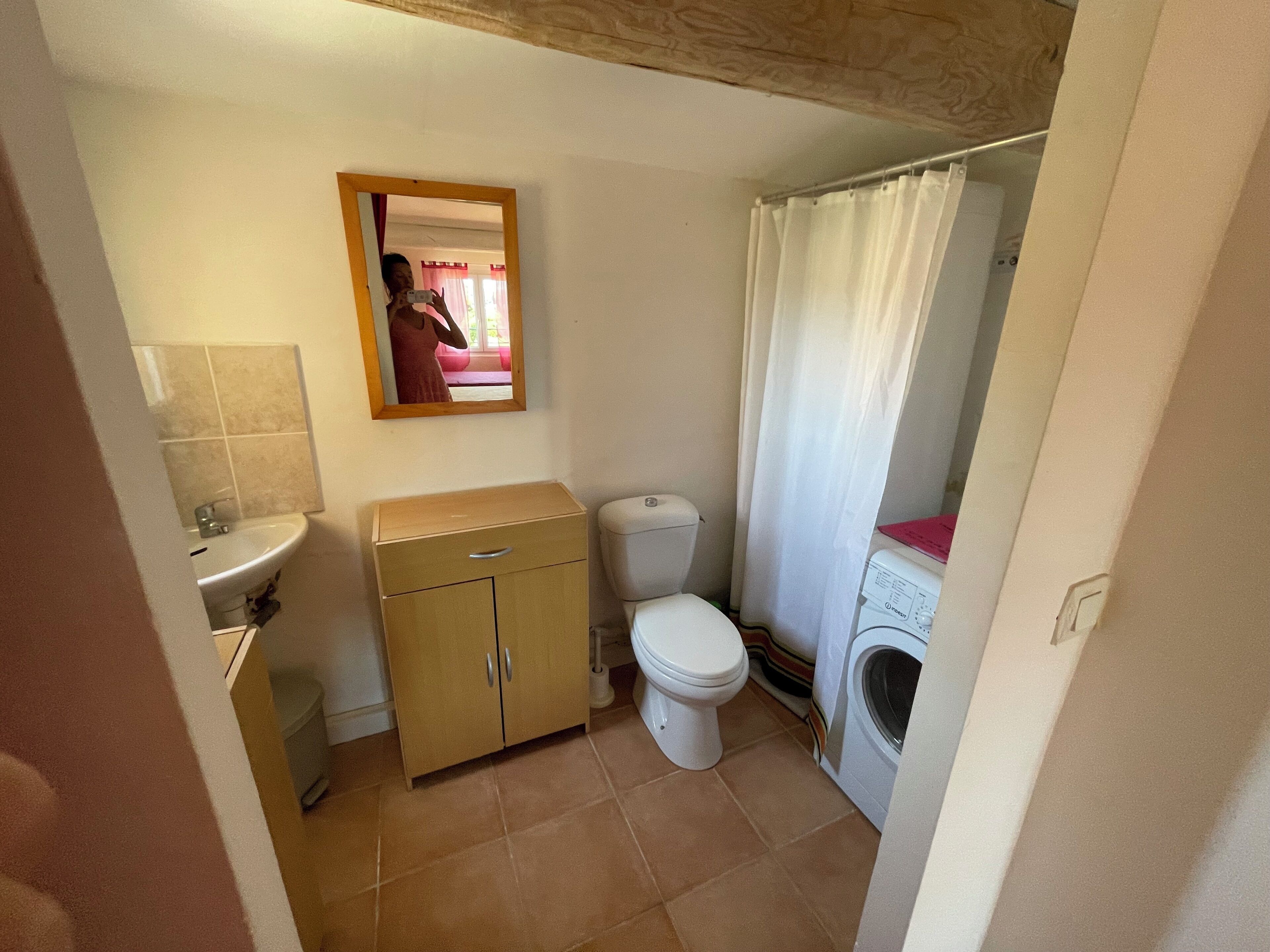 A compact bathroom with a sink, toilet, and washing machine.