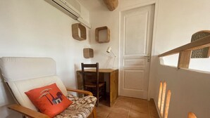 A room with a white chair, a wooden table, and a door.