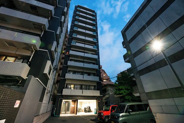 A multi-story building with a parking area in front. - SPAZIO 1 Canal Hakata (Fukuoka)