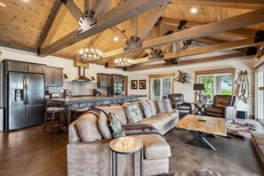 A spacious living area with a large sofa, a coffee table, and a fireplace.