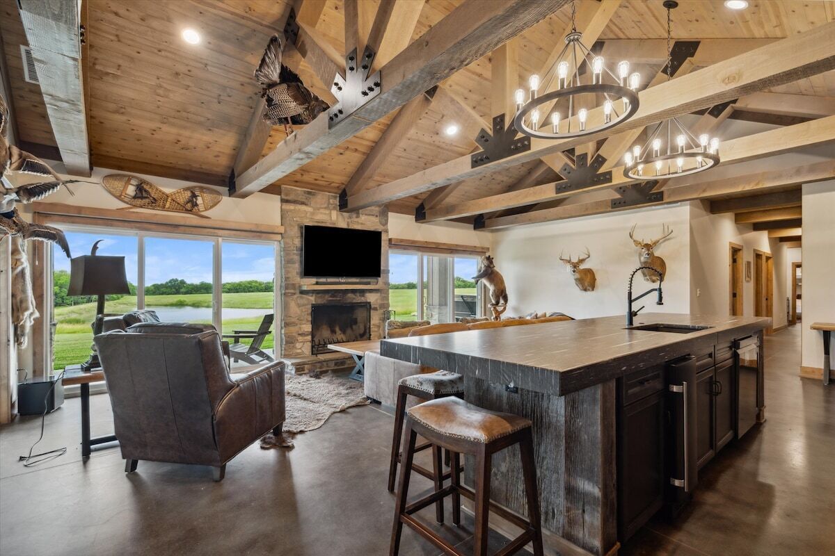 Una cocina amplia con una isla grande, chimenea de piedra y vistas al exterior.