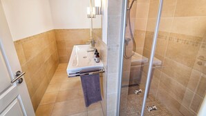 Un baño con lavamanos, espejo y ducha.