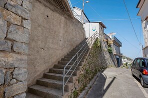 A stone staircase leading up to a building with a balcony, a parked car, and a clear sky. - Room 'Camera Furore Sea View' with Sea View, Wi-Fi and Air Conditioning (Furore)