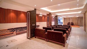 A spacious lobby with a row of plush armchairs, a patterned floor, and a modern ceiling design. - Roli Residency (Barasat)