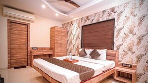 A modern bedroom with a wooden bed frame, a built-in wardrobe, and a large window with a brown blind. - Roli Residency (Barasat)