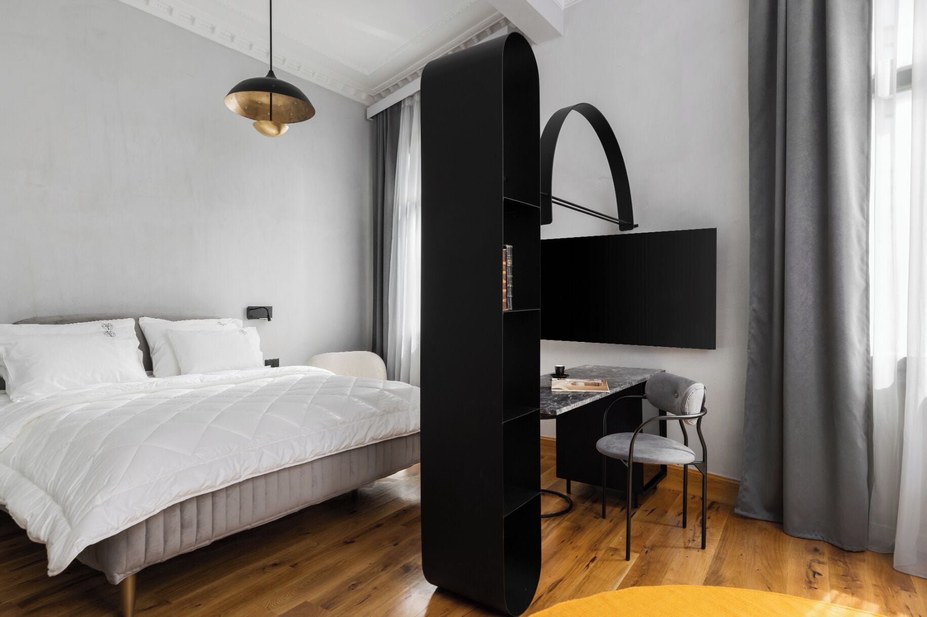 A modern bedroom with a bed, a desk, and a chair.