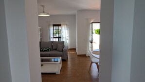 Ein großzügiger Wohnbereich mit einer Couch, einem Couchtisch und Blick ins Freie.