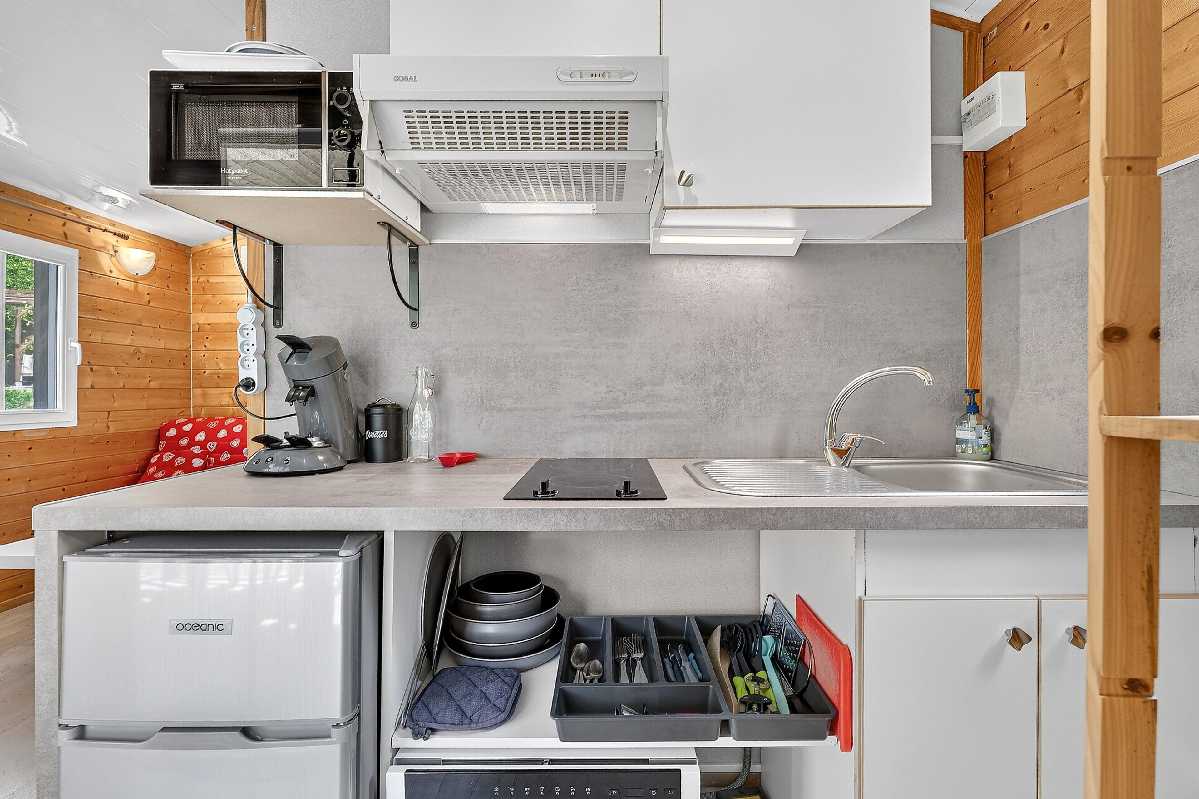 Een moderne keuken met ingebouwde apparatuur, een spoelbak en berglades.