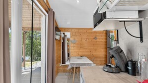 Una cocina compacta con cafetera, microondas y una pequeña mesa.