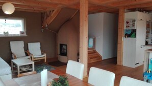 A cozy interior with a dining area, a kitchen, and a staircase. - Eco clay & straw villa with mountain scenery (Žiar)