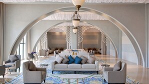 A spacious lobby with a central seating area, arched ceiling, and patterned floor.
