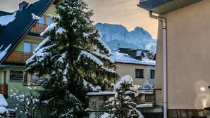 A snow-covered mountain landscape with a building featuring a balcony and a sign. - AMI ZAKOPANE (Zakopane)