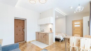A modern apartment with a kitchen, dining area, and a bedroom. - AMI ZAKOPANE (Zakopane)