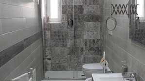 Un baño con ducha, inodoro y lavamanos.