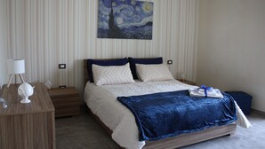 Un dormitorio ordenado con cama, mesitas de noche y un cuadro colgado en la pared.