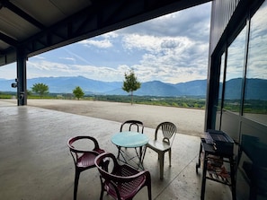 Un'area salotto all'aperto coperta con vista sulle montagne e un cielo sereno.