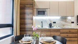 A modern kitchen with wooden cabinets, a built-in microwave, and a marble countertop.