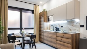 A modern kitchen with wooden cabinets, a marble countertop, and a dining area with a table and chairs.